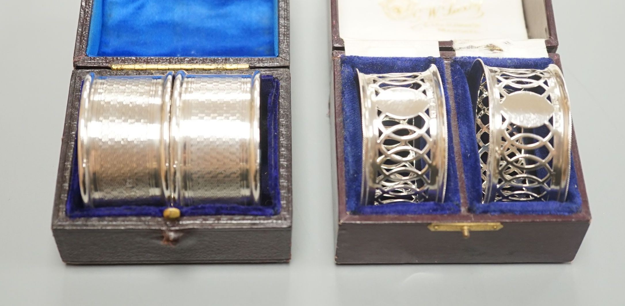 A cased pair of George V engine turned silver napkin rings, by Charles Horner, Chester, 1923 and an Edwardian cased pair of silver napkin rings.